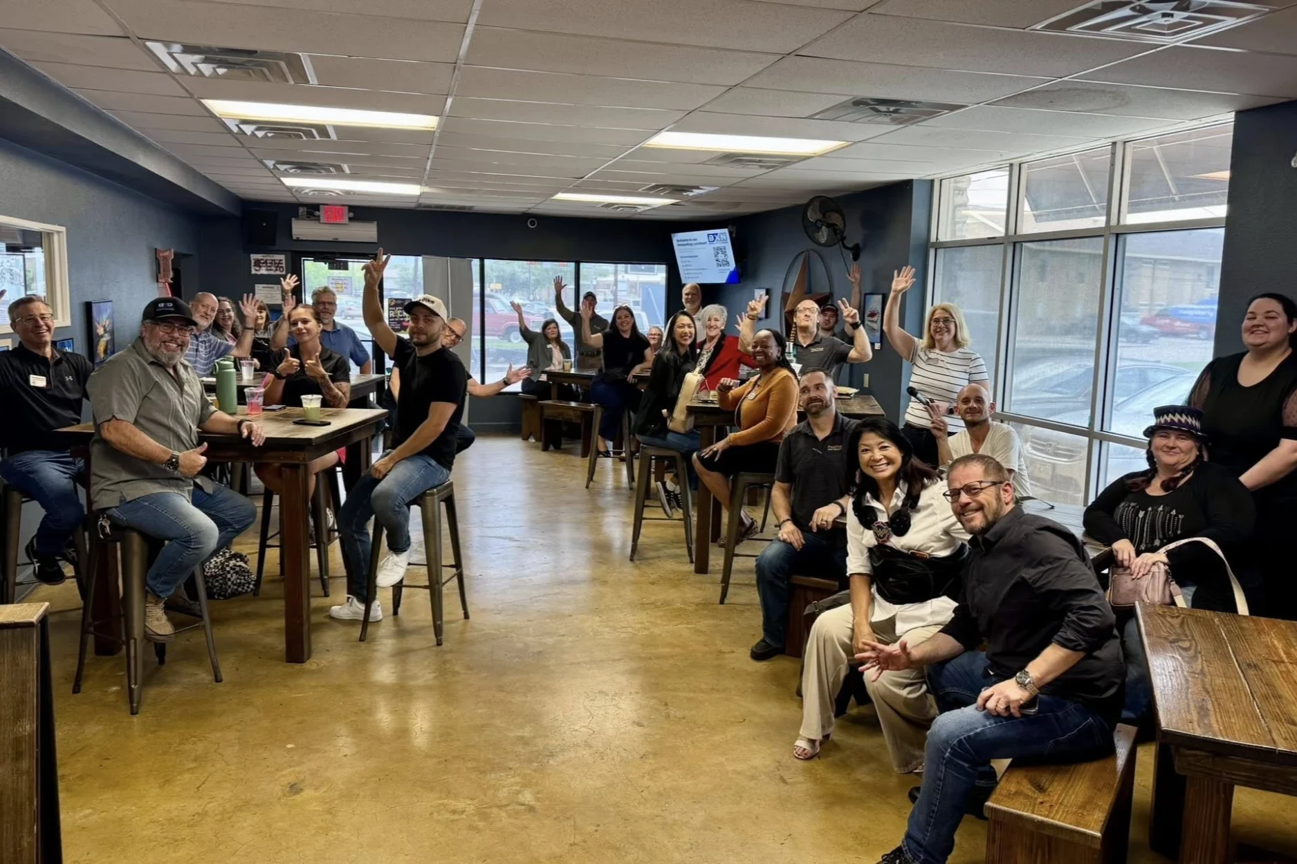 A BXN networking meeting in Austin, members waving at the camera